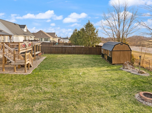 view of yard with an outbuilding, a fenced backyard, a fire pit, a residential view, and a shed