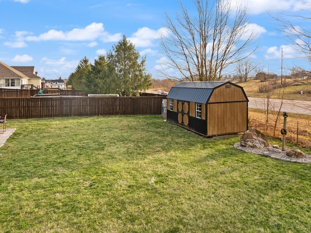 view of yard with an outbuilding, a shed, and a fenced backyard