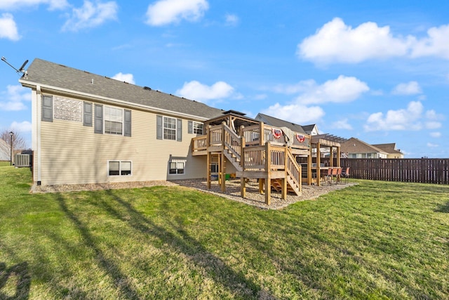 back of house featuring cooling unit, a shingled roof, fence, a yard, and a wooden deck