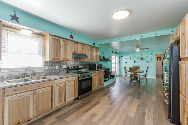 kitchen featuring light brown cabinets, stainless steel appliances, and a sink