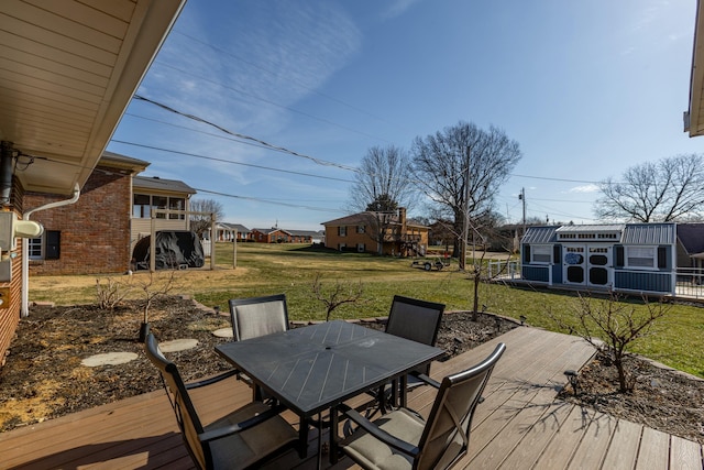 wooden deck with outdoor dining area and a yard