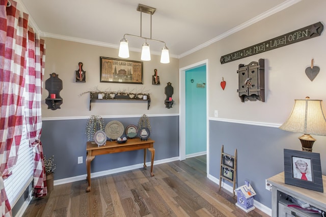 interior space with ornamental molding, wood finished floors, and baseboards