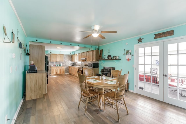 dining area featuring light wood finished floors and crown molding