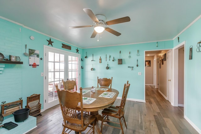 dining space featuring baseboards, ornamental molding, wood finished floors, and french doors