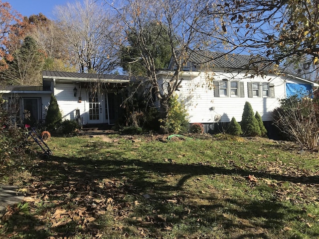 rear view of house featuring a standing seam roof, metal roof, french doors, and a yard