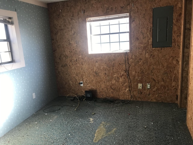 unfurnished room featuring electric panel and wallpapered walls