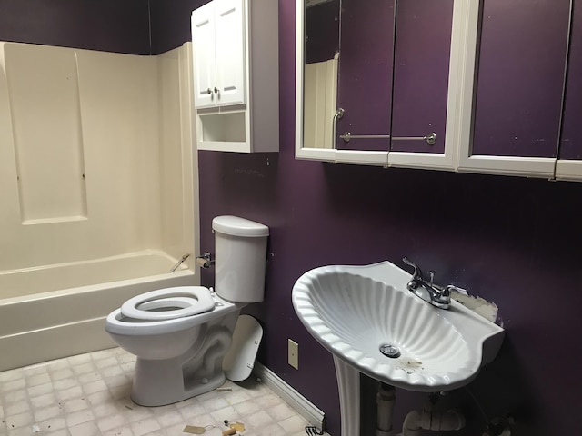 bathroom with toilet, shower / bath combination, a sink, and tile patterned floors