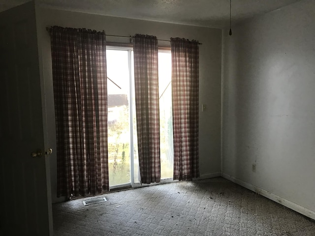 empty room featuring carpet and visible vents