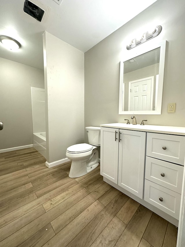 full bath with vanity, wood finished floors, toilet, and baseboards