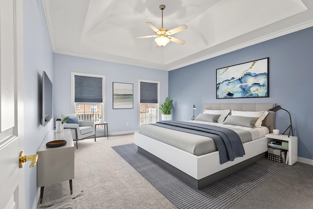 carpeted bedroom with a ceiling fan, a raised ceiling, crown molding, and baseboards