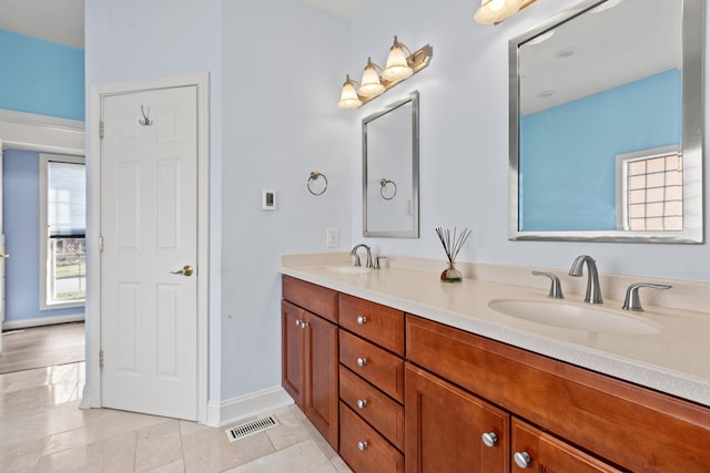 full bathroom with double vanity, tile patterned flooring, a sink, and visible vents