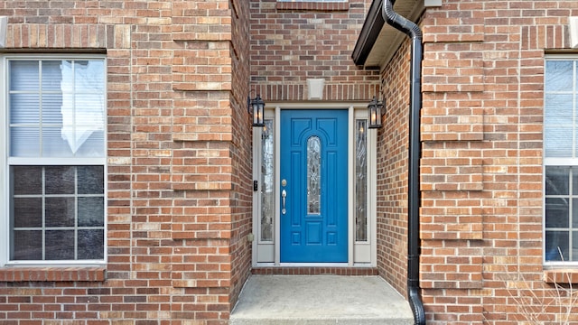 property entrance featuring brick siding