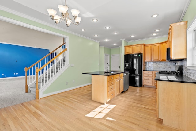 kitchen featuring dark countertops, black fridge with ice dispenser, stainless steel dishwasher, a sink, and range