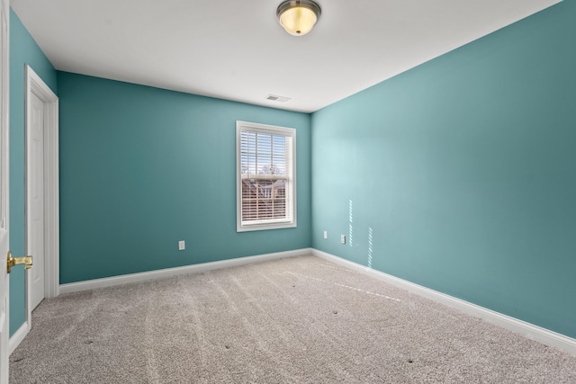 carpeted spare room featuring baseboards and visible vents