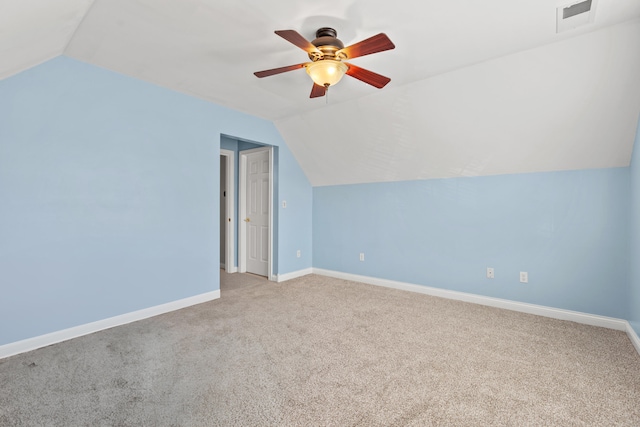 additional living space featuring baseboards, visible vents, vaulted ceiling, and light colored carpet