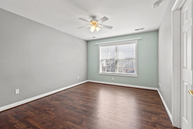 empty room featuring a ceiling fan, visible vents, baseboards, and wood finished floors