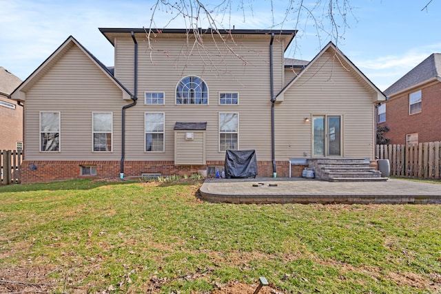 rear view of property featuring entry steps, a yard, a patio, and fence