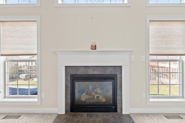 room details with baseboards, visible vents, and a tiled fireplace