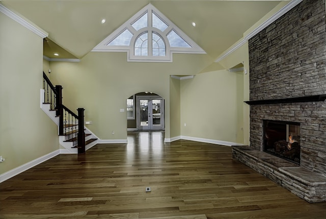 unfurnished living room with ornamental molding, wood finished floors, stairs, french doors, and high vaulted ceiling