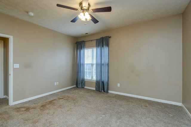 empty room with ceiling fan, carpet floors, a textured ceiling, and baseboards