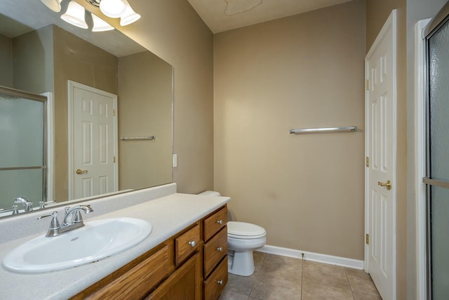 bathroom featuring tile patterned flooring, a shower with door, vanity, and toilet