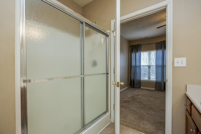 bathroom featuring a stall shower, baseboards, and vanity