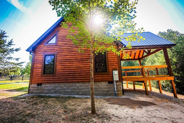 view of side of home featuring crawl space and faux log siding