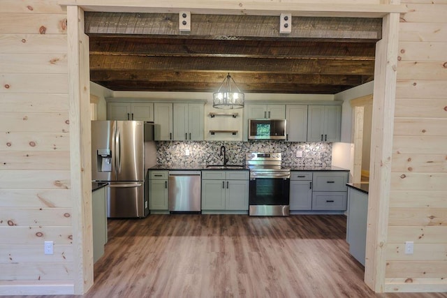 kitchen with tasteful backsplash, dark countertops, dark wood-style floors, stainless steel appliances, and green cabinetry