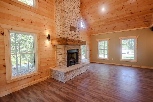 unfurnished living room featuring high vaulted ceiling, wood walls, a fireplace, wood finished floors, and wood ceiling