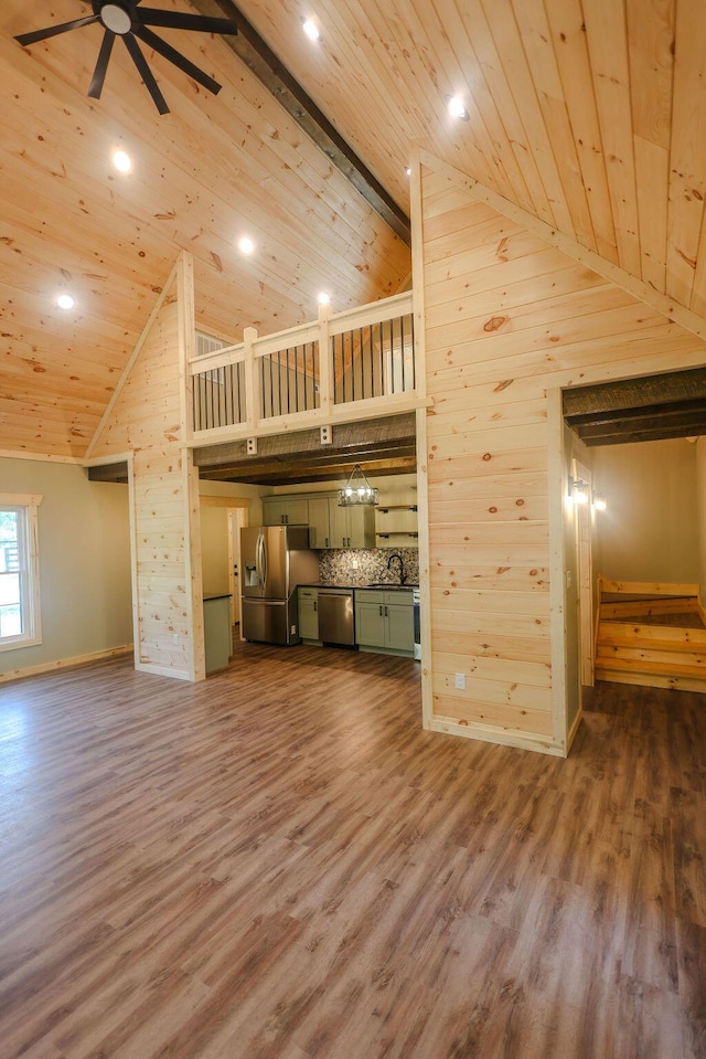 unfurnished living room with high vaulted ceiling, a ceiling fan, wooden ceiling, and wood finished floors