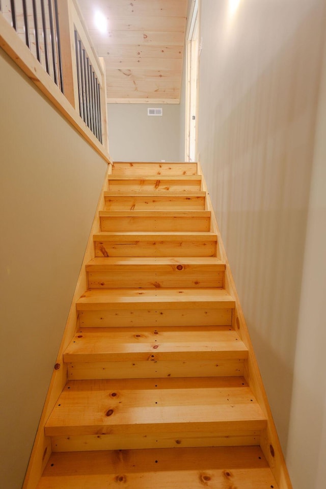 stairway with wood ceiling and visible vents