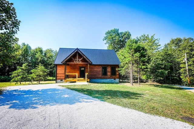 view of front of house with driveway, metal roof, crawl space, covered porch, and a front yard