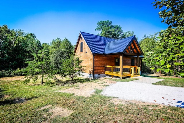 view of side of property with metal roof, driveway, and crawl space