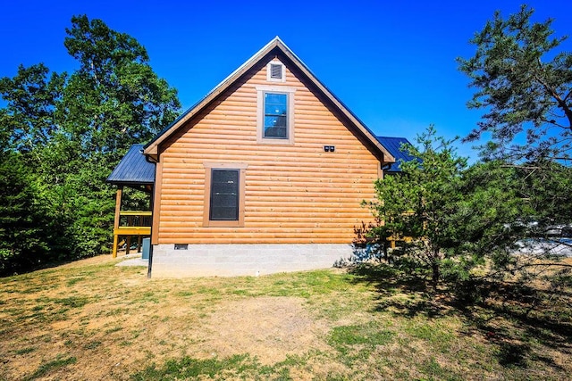 view of side of home with crawl space, metal roof, and a yard