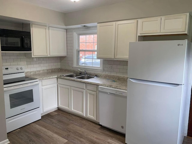 kitchen featuring white appliances, dark wood-style flooring, a sink, light countertops, and decorative backsplash