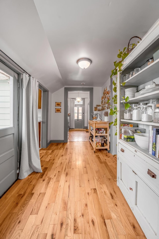 interior space featuring light wood-style floors and vaulted ceiling