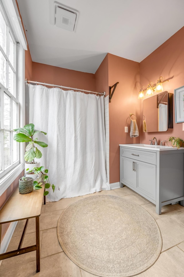 full bathroom featuring a wealth of natural light, vanity, and visible vents