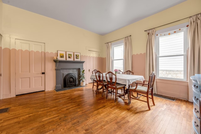 dining space featuring visible vents and hardwood / wood-style flooring