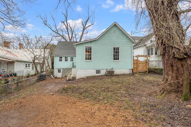 rear view of house featuring central air condition unit, a gate, and fence