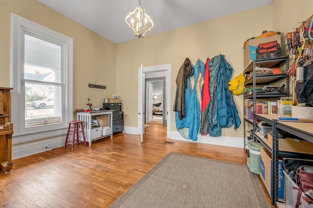 interior space with a chandelier, wood finished floors, and baseboards