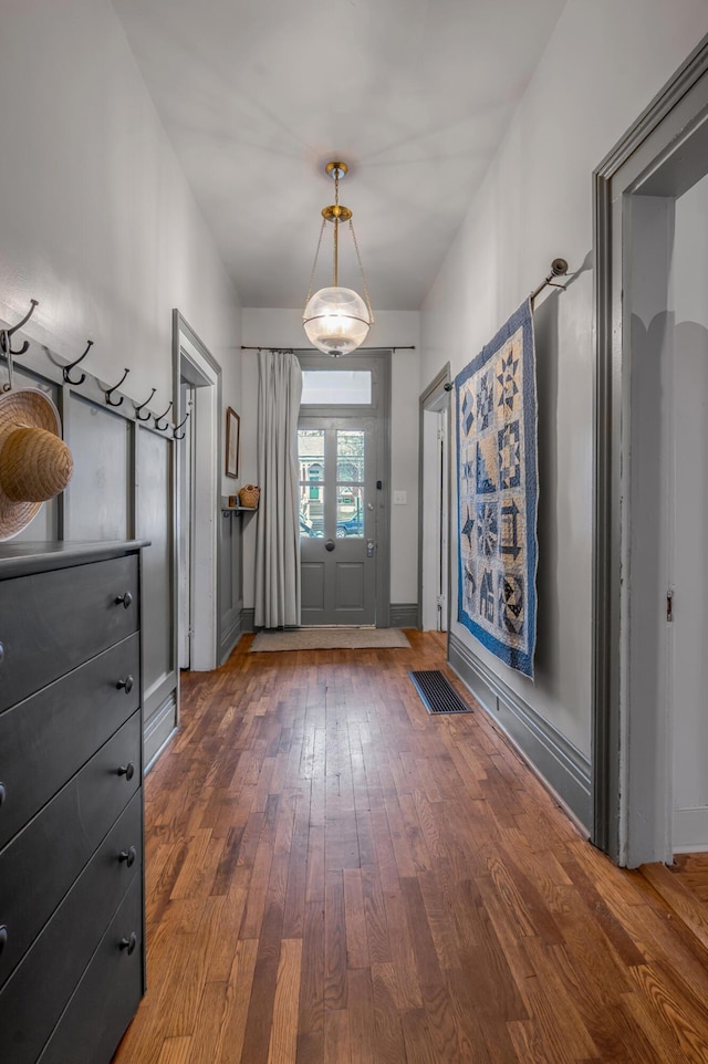 entryway featuring hardwood / wood-style floors, visible vents, and baseboards