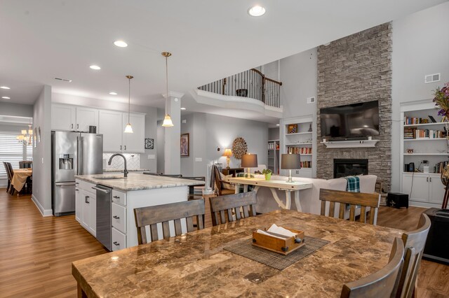 dining area with recessed lighting, visible vents, wood finished floors, and a stone fireplace