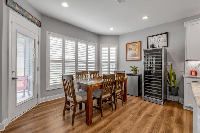 dining space featuring visible vents, baseboards, wine cooler, light wood-type flooring, and recessed lighting