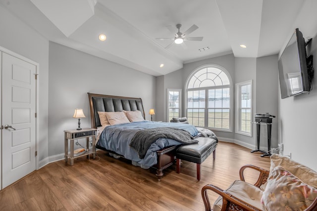 bedroom featuring lofted ceiling, baseboards, and wood finished floors