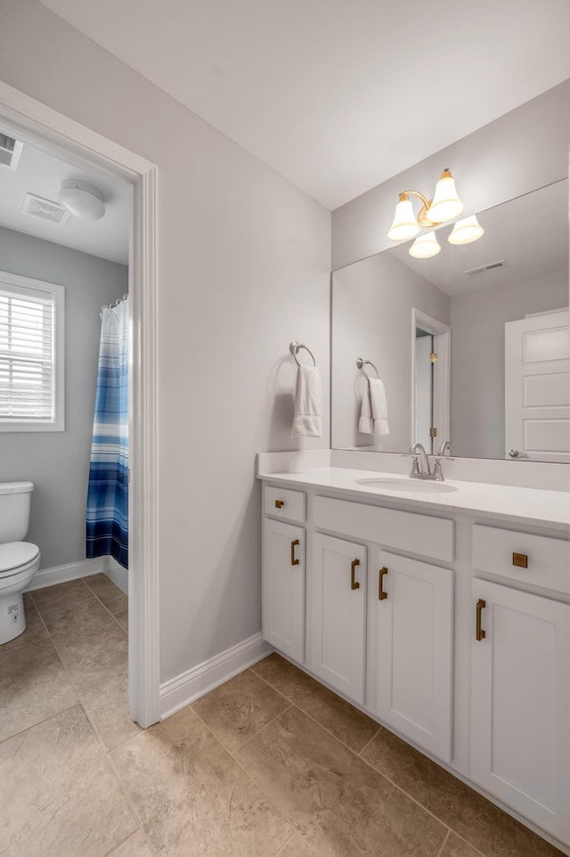 bathroom with baseboards, visible vents, vanity, and toilet