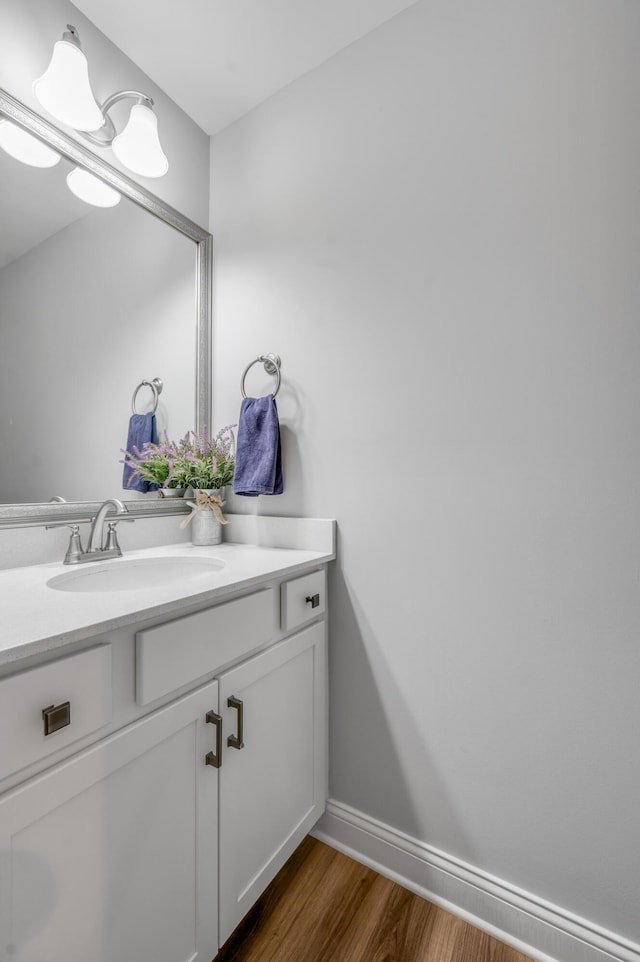 bathroom featuring vanity, baseboards, and wood finished floors