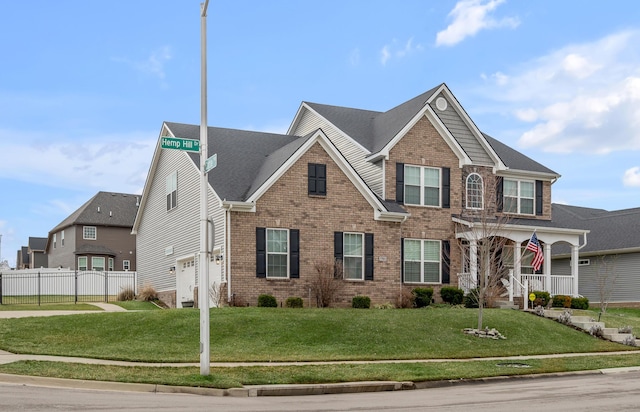 view of front of property with brick siding, a front lawn, and fence