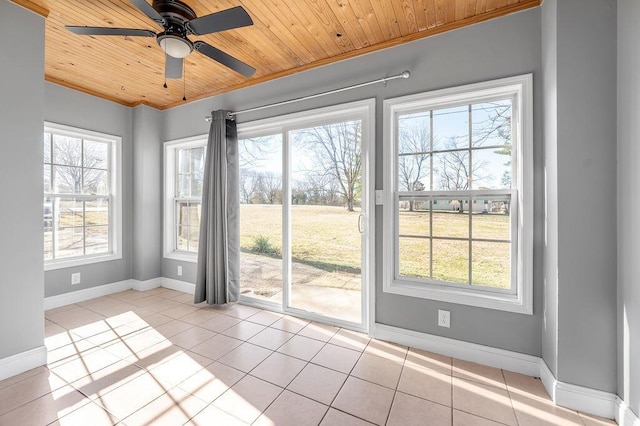 interior space featuring wooden ceiling, light tile patterned floors, baseboards, and ornamental molding