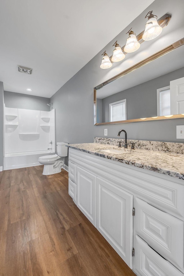 bathroom featuring visible vents, vanity, toilet, and wood finished floors