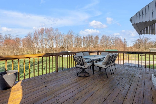 wooden deck with a yard and outdoor dining space